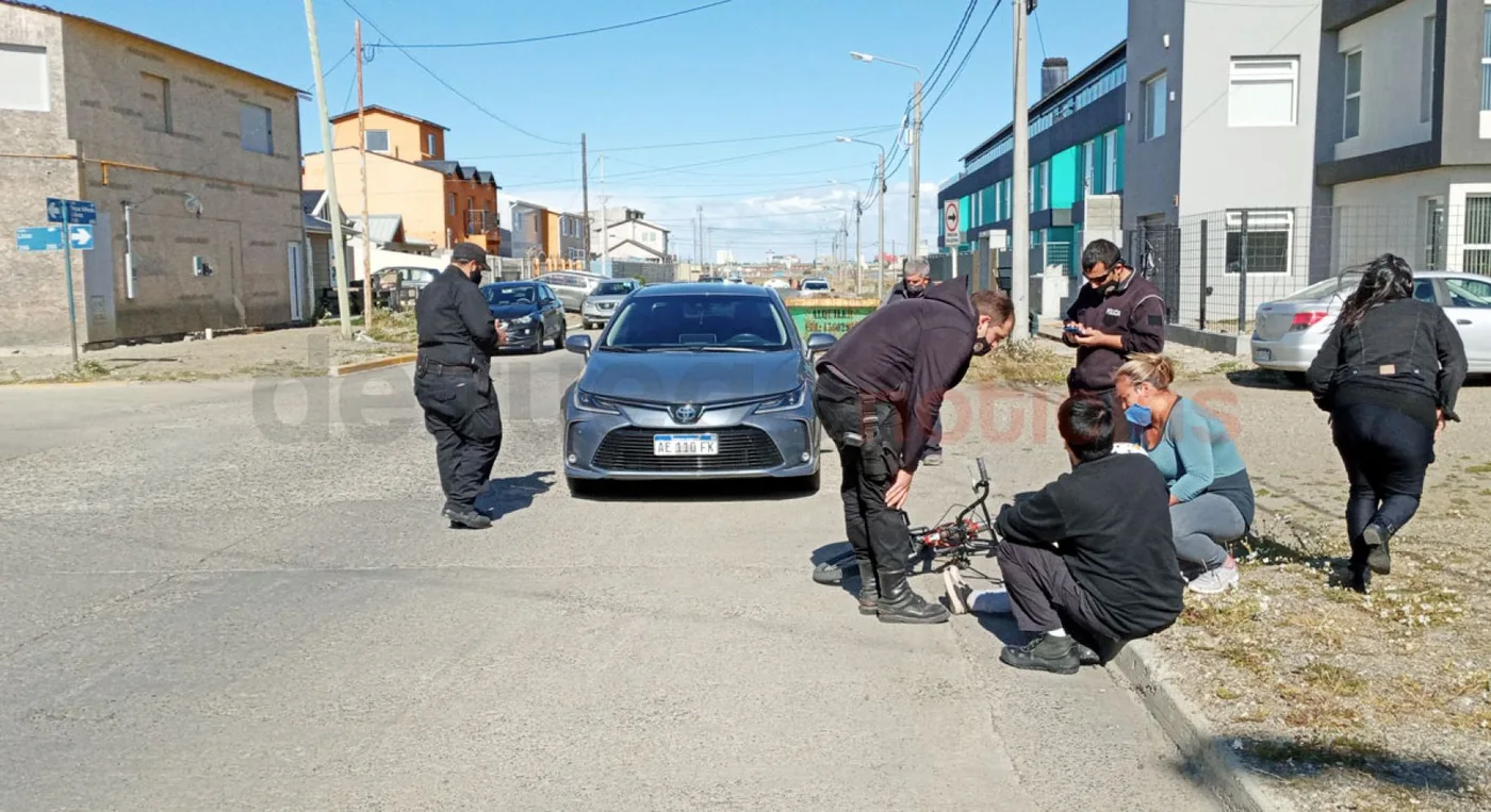 El Toyota que atropelló al nene y personal policial trata de calmar al niño, junto a su madre.