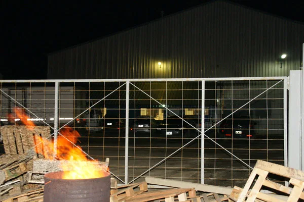 El tacho con fuego en el acceso al predio, símbolo de la protesta.