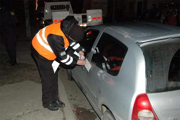 Un inspector coloca la faja de secuestro en uno de los vehículos decomisados.