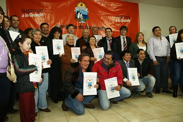 Gustavo Melella y su gabinete posan junto a los beneficiarios.