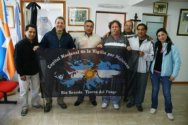 Veteranos de Guerra y amigos posan junto a la bandera alusiva.