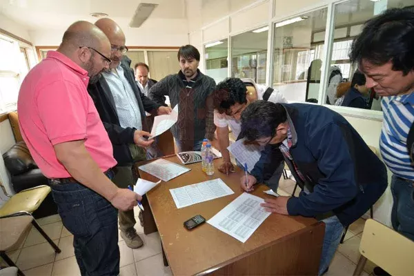 Marcelo Córdoba firma el acuerdo. Lo mira de cerca Felipe Concha.