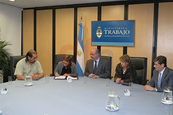 Firma Ríos y la miran con atención Tomada, Rial y Martínez.