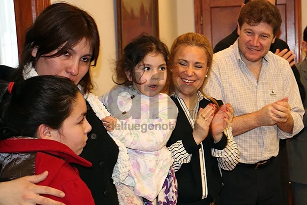 Gustavo Melella junto a la familia de la niña rescatada de un cuarto piso.